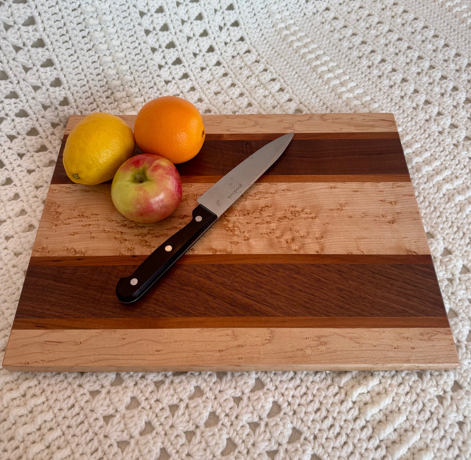 Birdseye, BlackWalnut, and Cherry 12x16 cutting board with fruits and knife. 
